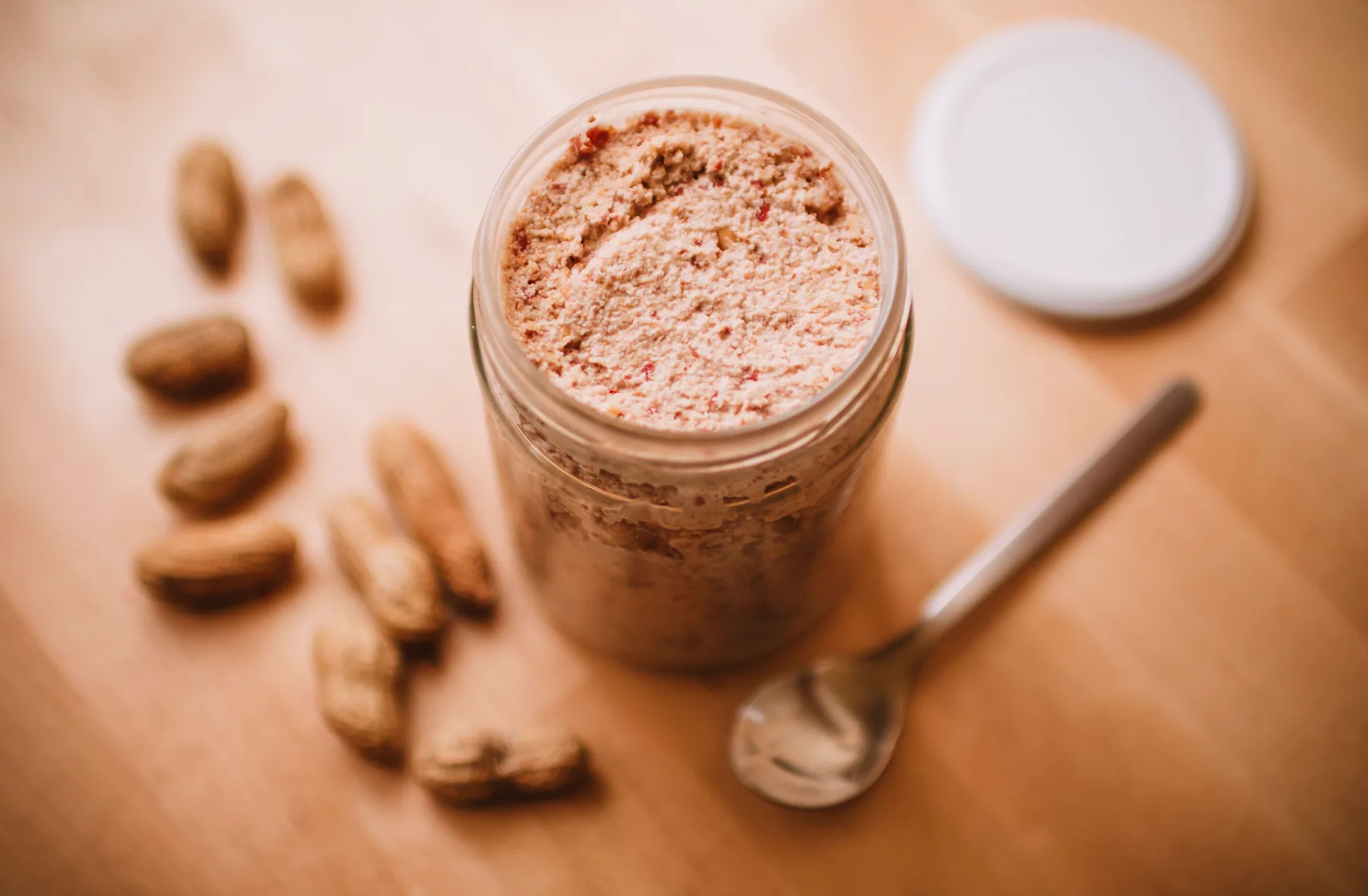 Peanut butter in a jar with peanuts